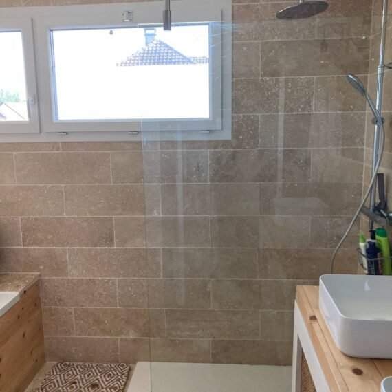 Travertin beige posé sur sol et murs et paroi de douche
